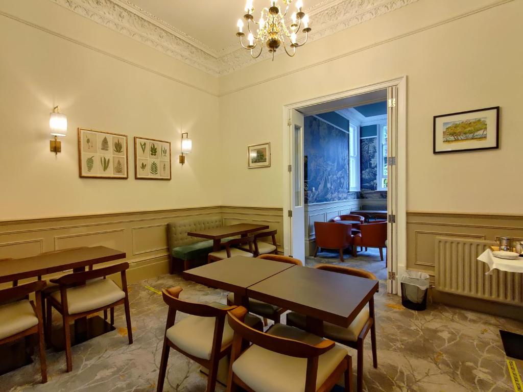 a room with a table and chairs in it at Blue Bells Hotel in London
