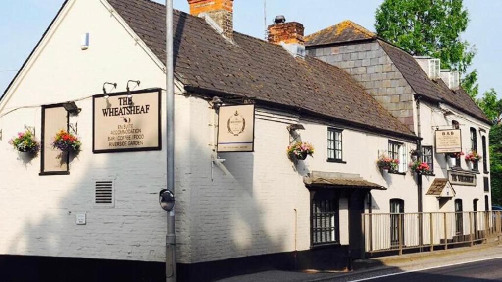 a white building with flowers on the side of it at The Wheatsheaf in Salisbury