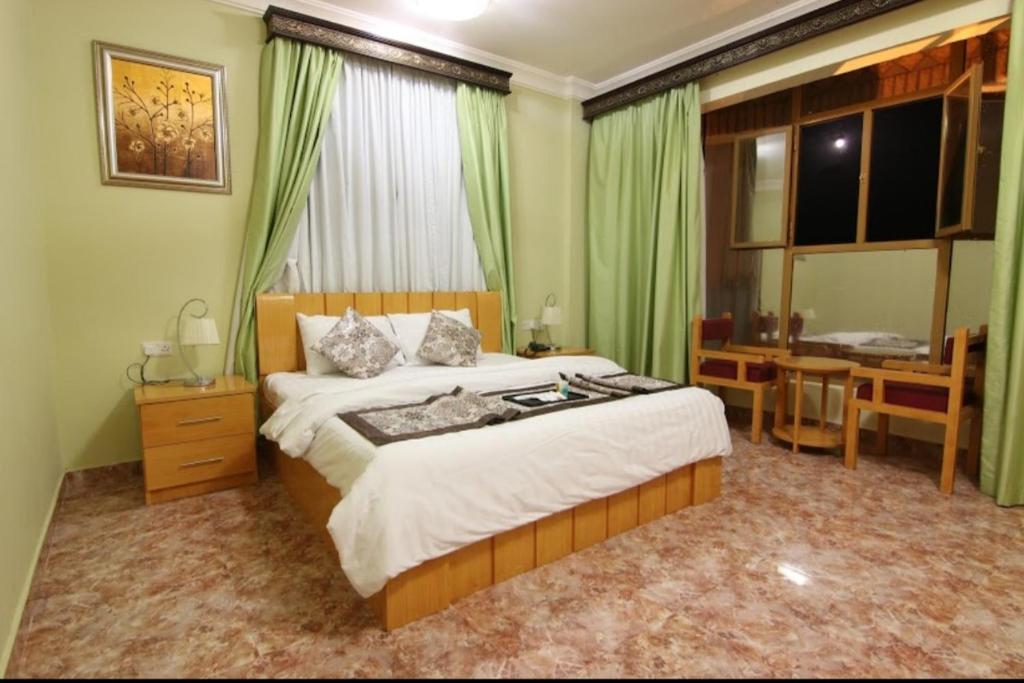 a bedroom with a bed and a desk and a window at DREAMLAND HOTEL APARTMENT NIZWA in Nizwa