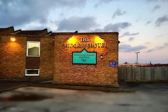 een bakstenen gebouw met een bord aan de zijkant bij Midlands Hotel in Mansfield