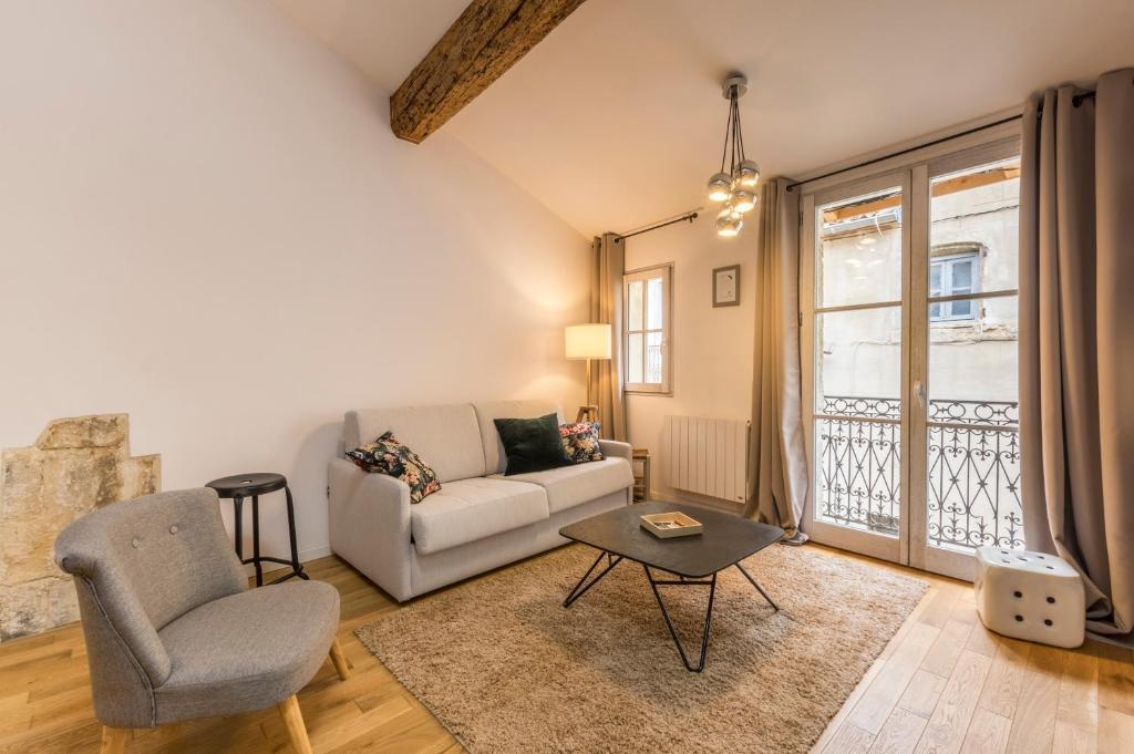 ein Wohnzimmer mit einem Sofa und einem Stuhl in der Unterkunft La Parenthèse Roucher Montpellier - Duplex Climatisé T2 Cœur écusson in Montpellier