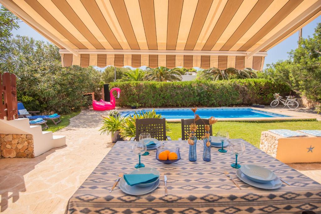 une terrasse avec une table et une piscine dans l'établissement Villa Isabel, à Santanyí