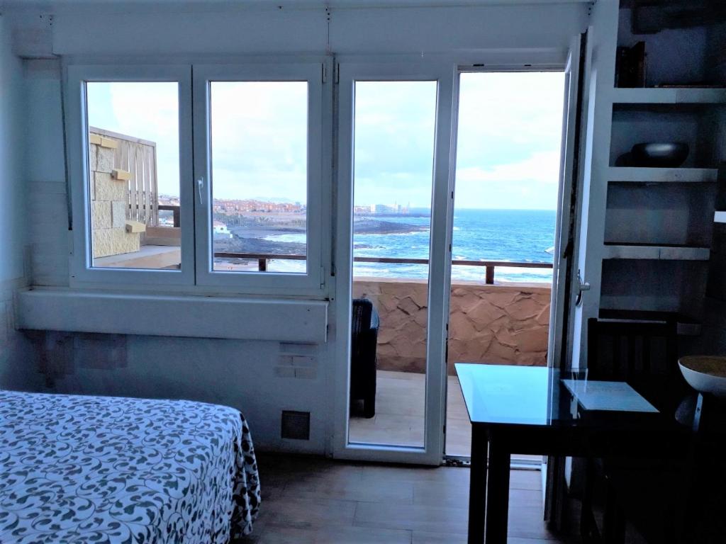 um quarto com uma cama e vista para o oceano em One room flat at the beach near house "Sanmao" em Telde