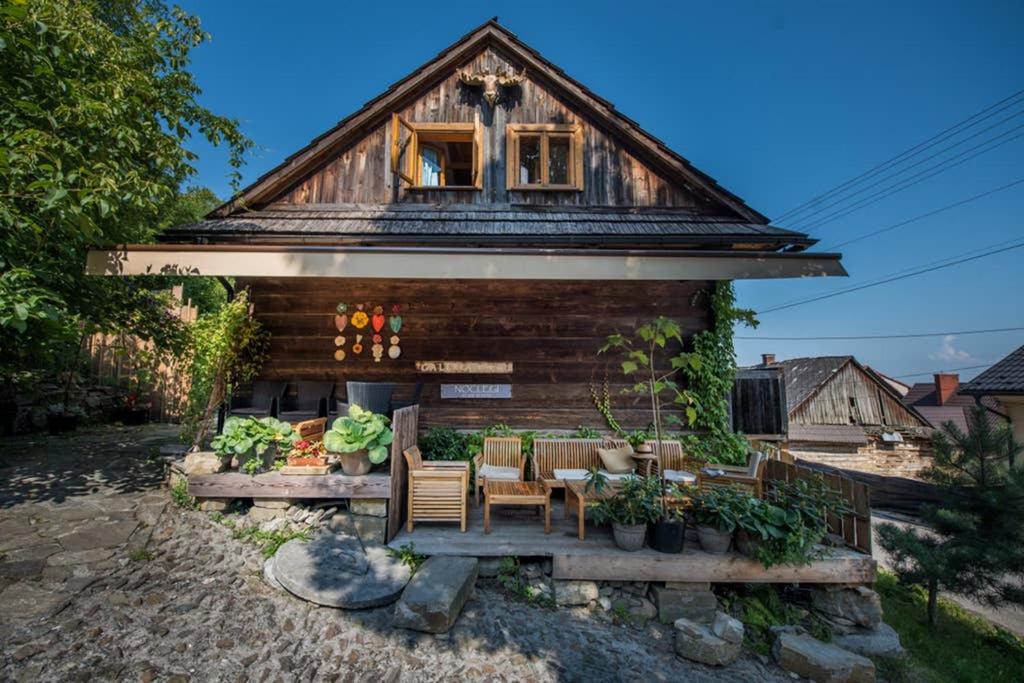una casa con una mesa y sillas frente a ella en Domek nad Galerią, en Lanckorona