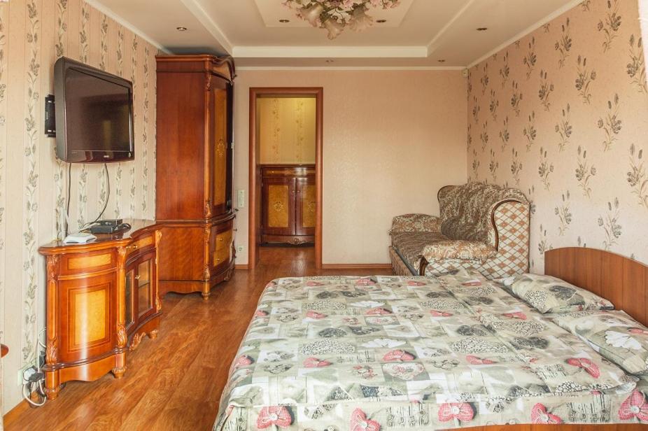 1 dormitorio con 1 cama, 1 silla y TV en Квартира по улице Большая Васильковская, 145/1, en Kiev