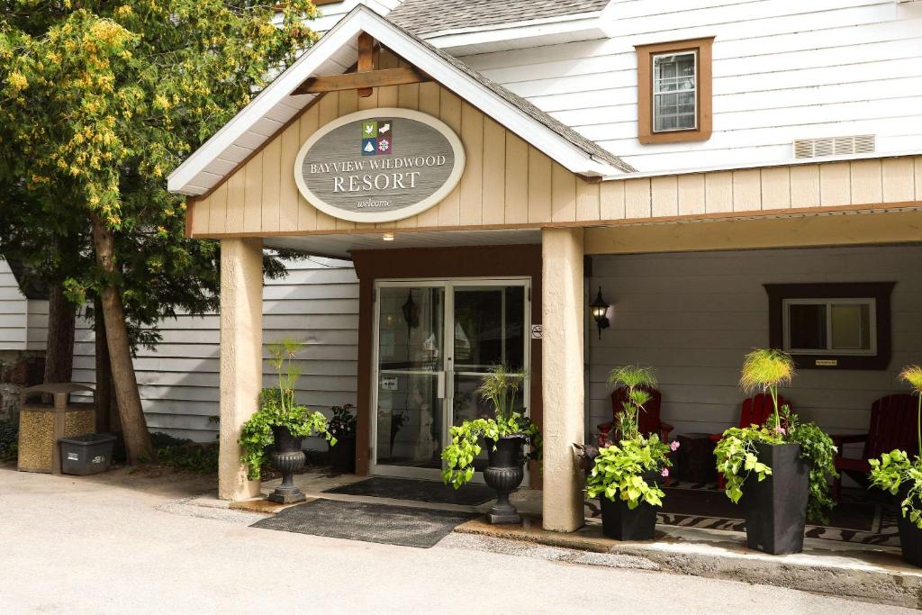 uma entrada frontal para um restaurante com vasos de plantas em Bayview Wildwood Resort, Ascend Hotel Collection em Severn