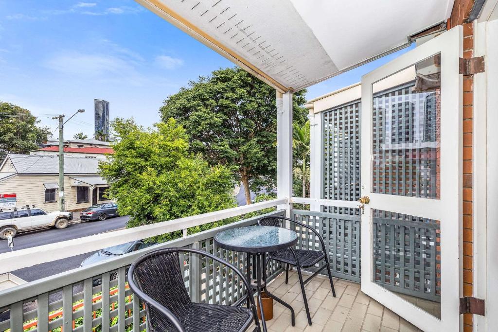 a balcony with a table and chairs and a view of a street at Spring Hill Terraces in Brisbane