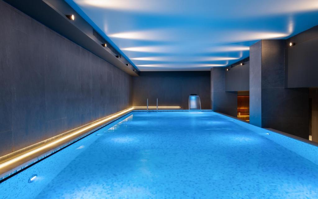 a swimming pool in a room with a blue ceiling at Mövenpick Moscow Taganskaya in Moscow