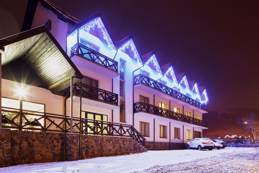 a building with christmas lights on it in the snow at Hostel Sich in Bukovel
