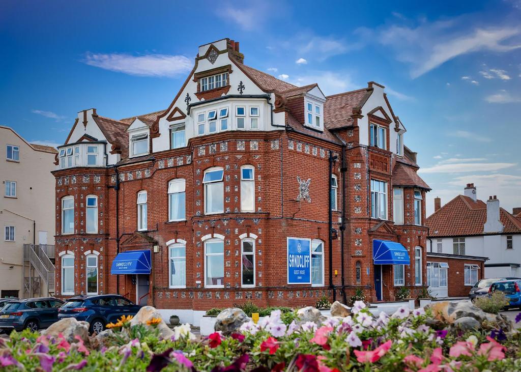 un gran edificio de ladrillo rojo en una calle de la ciudad en Sandcliff Guest House en Cromer