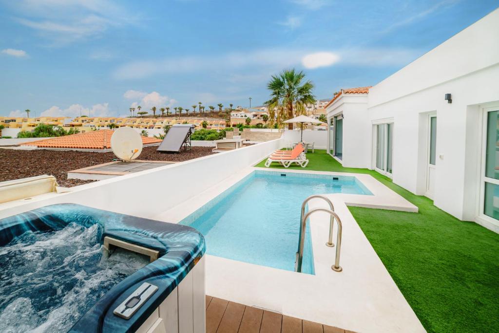 a swimming pool in the backyard of a house at Villa Carlota Costa Adeje in Adeje