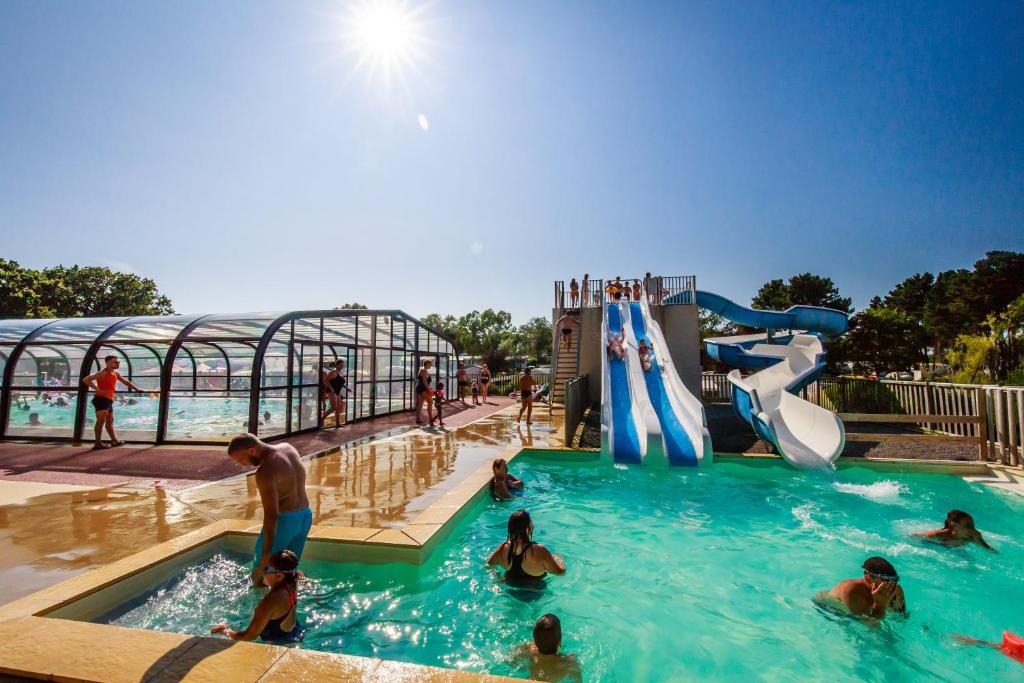- un groupe de personnes dans une piscine d'un parc aquatique dans l'établissement Mobil Home XXL 4 chambres - Camping Le Domaine de Bréhadour, à Guérande