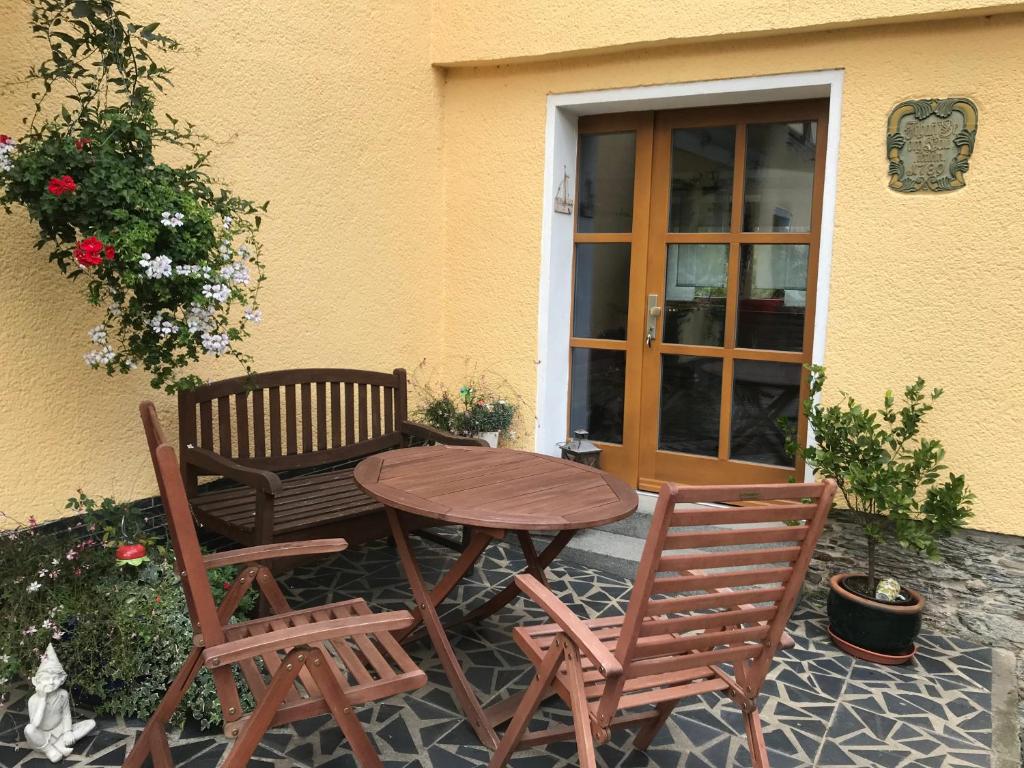 un tavolo e due sedie seduti accanto a una porta di Am Brunnen Merkendorf a Zeulenroda