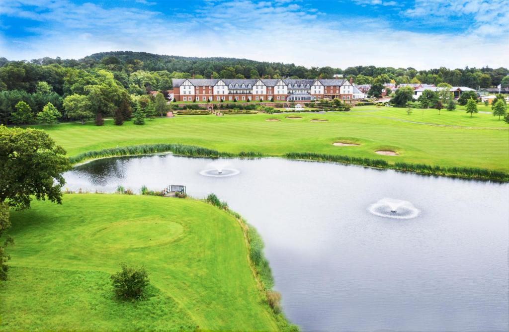 an aerial view of a resort with a pond at Carden Park Hotel, Golf Resort and Spa in Tilston