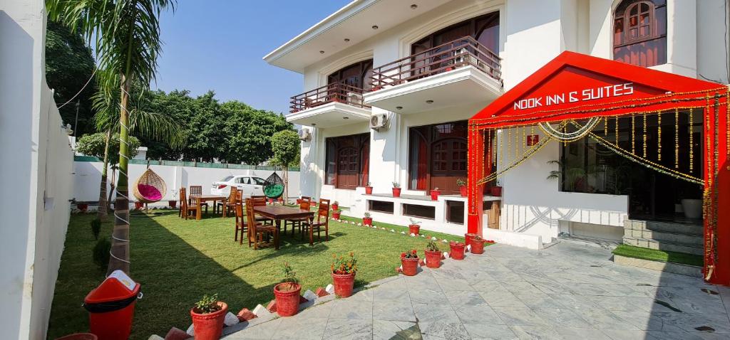 a building with a table and chairs in a yard at Nook Inn & Suites - MG ROAD METRO in Gurgaon