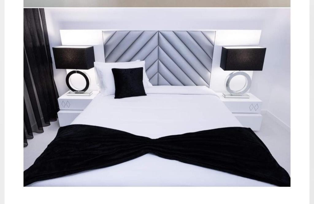 - une chambre dotée d'un lit blanc avec cravate noire dans l'établissement Central Apartment in Pombal, à Pombal