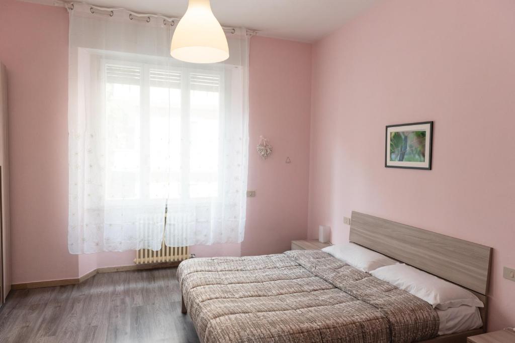 a bedroom with a bed and a large window at Poggio del Sole Guest House in Arezzo