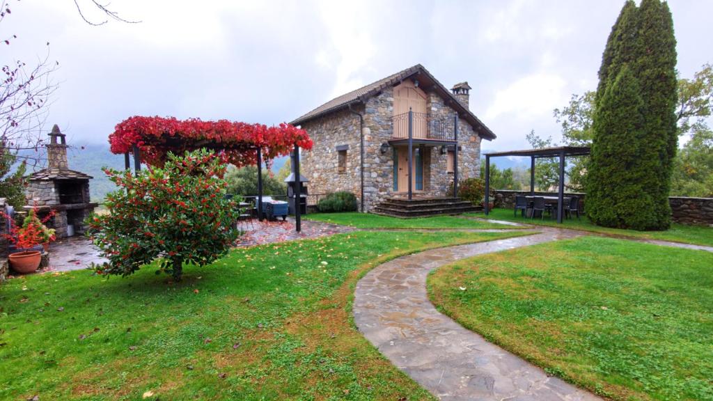 a stone house with a garden in front of it at Casas Cleto - Laspuña in Laspuña