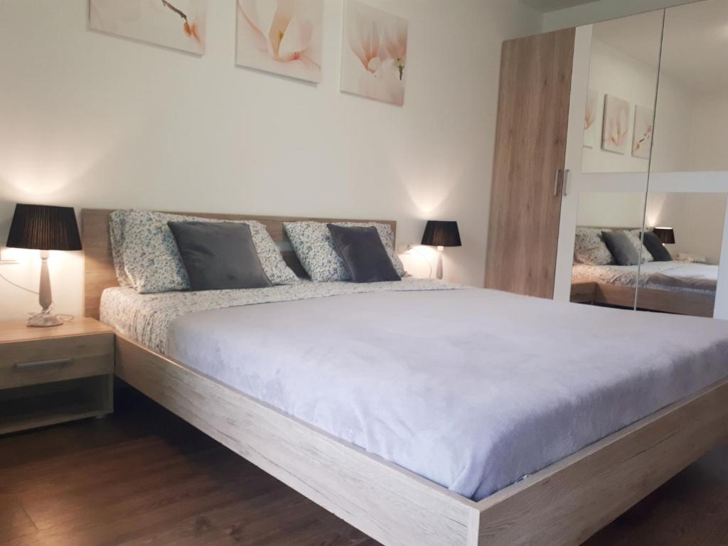 a bedroom with a large bed and a mirror at Apartment Bruneck Central in Brunico