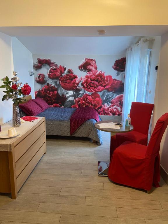 1 dormitorio con 1 cama con flores rojas en la pared en PIVOINE Chambre d hotes, en Fralignes