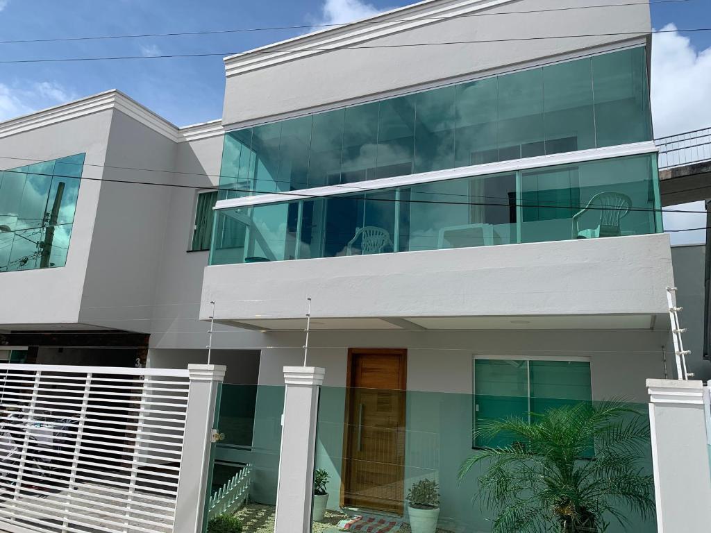 Casa blanca grande con ventanas de cristal en CASA NO CENTRO, en Itapema