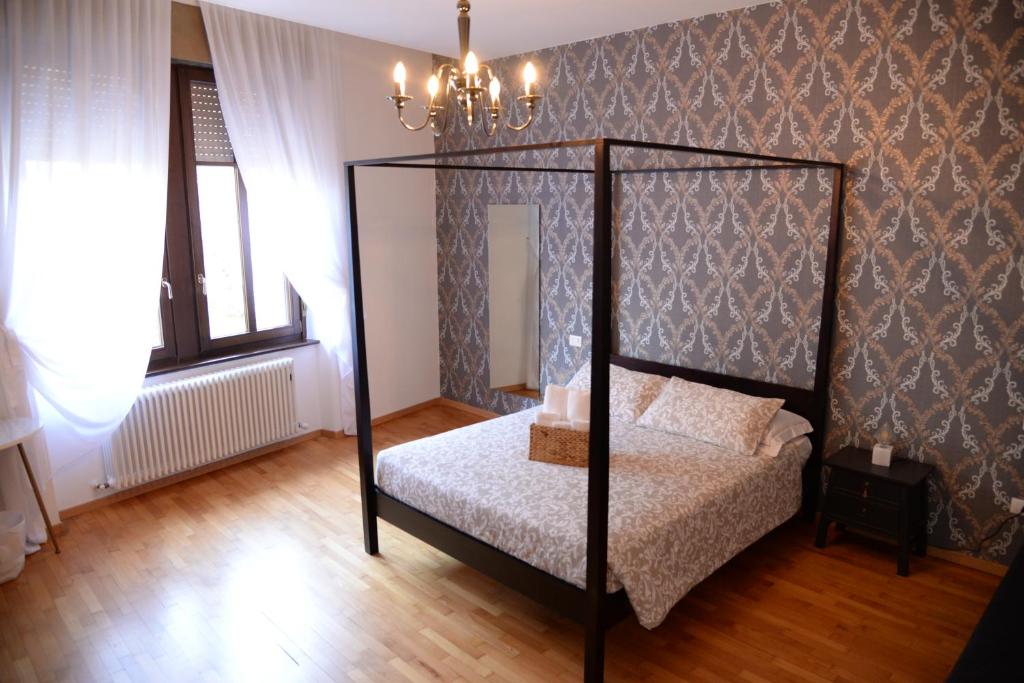a bedroom with a four poster bed and a chandelier at B&B Trento - Only self check-in in Trento