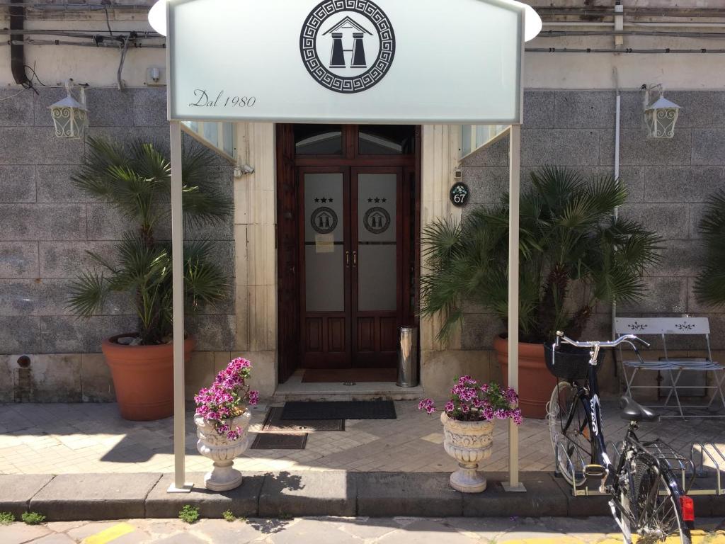 znak przed budynkiem z kwiatami w obiekcie Hotel Archimede Ortigia w Syrakuzach