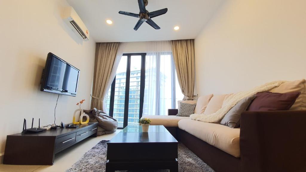 uma sala de estar com um sofá e uma televisão de ecrã plano em KLGateway Premium Residence Mid Valley em Kuala Lumpur