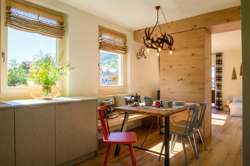 eine Küche und ein Esszimmer mit einem Tisch und Stühlen in der Unterkunft Nido di montagna * Mountain Nest in Dimaro