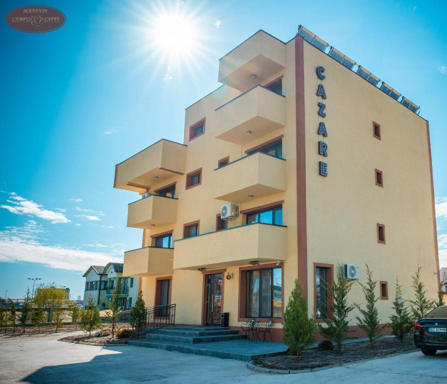 a large building with the sun in the sky at Campus Caffe Mansion in Buzău