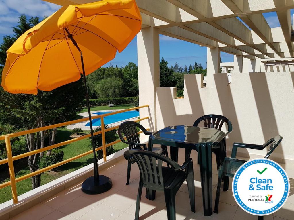 a table and chairs and an umbrella on a deck at Copacabana by Check-in Portugal in Vilamoura