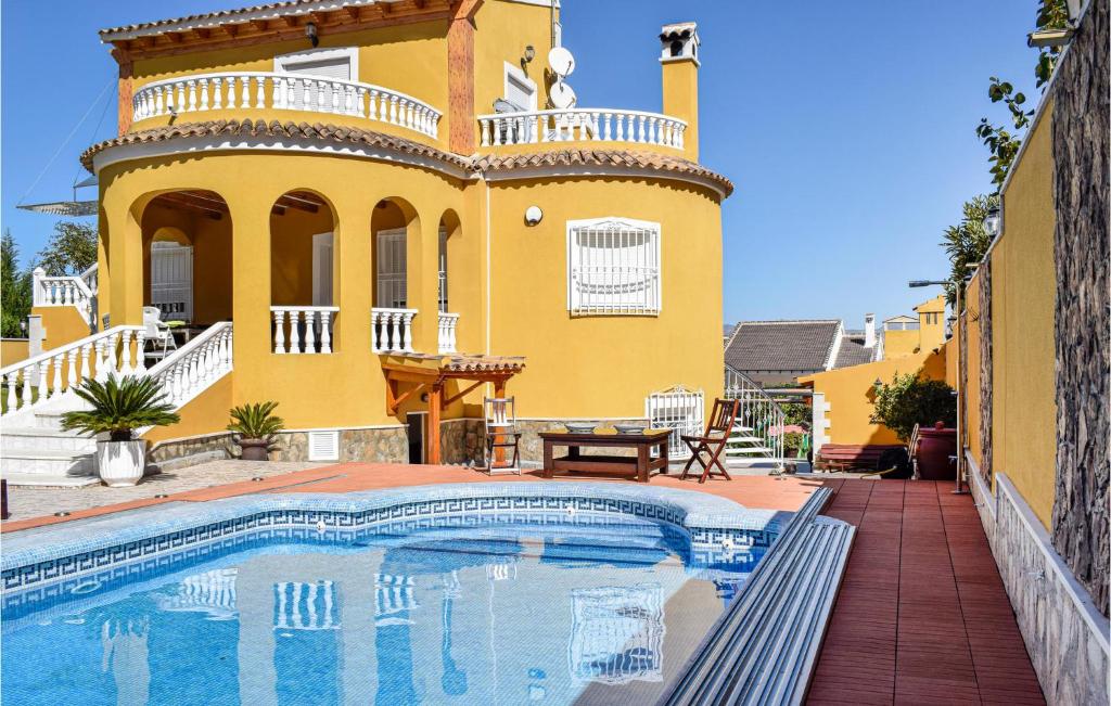 a yellow house with a swimming pool in front of it at Cozy Home In Orihuela With Outdoor Swimming Pool in Orihuela