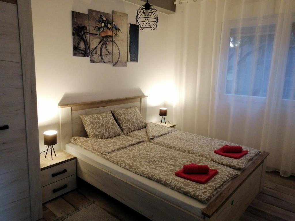 um quarto com uma cama com duas almofadas vermelhas em Apartman Petreš em Sombor