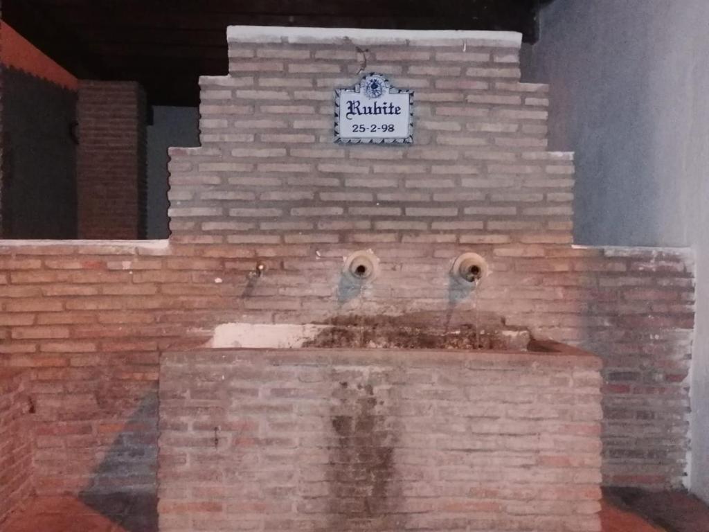 a brick wall with a clock on top of it at Casa Amat in Rubite