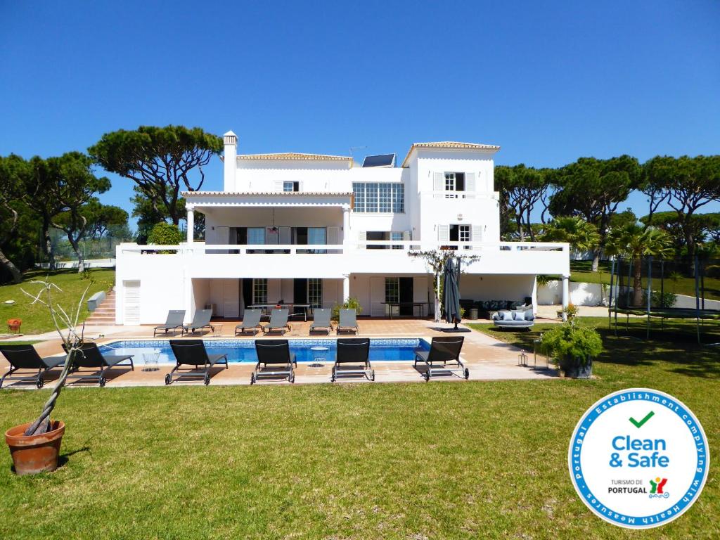 a large white house with a swimming pool and a yard at Fonte Santa by Check-in Portugal in Quarteira