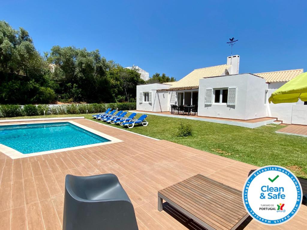 a villa with a swimming pool and a house at Galo by Check-in Portugal in Albufeira