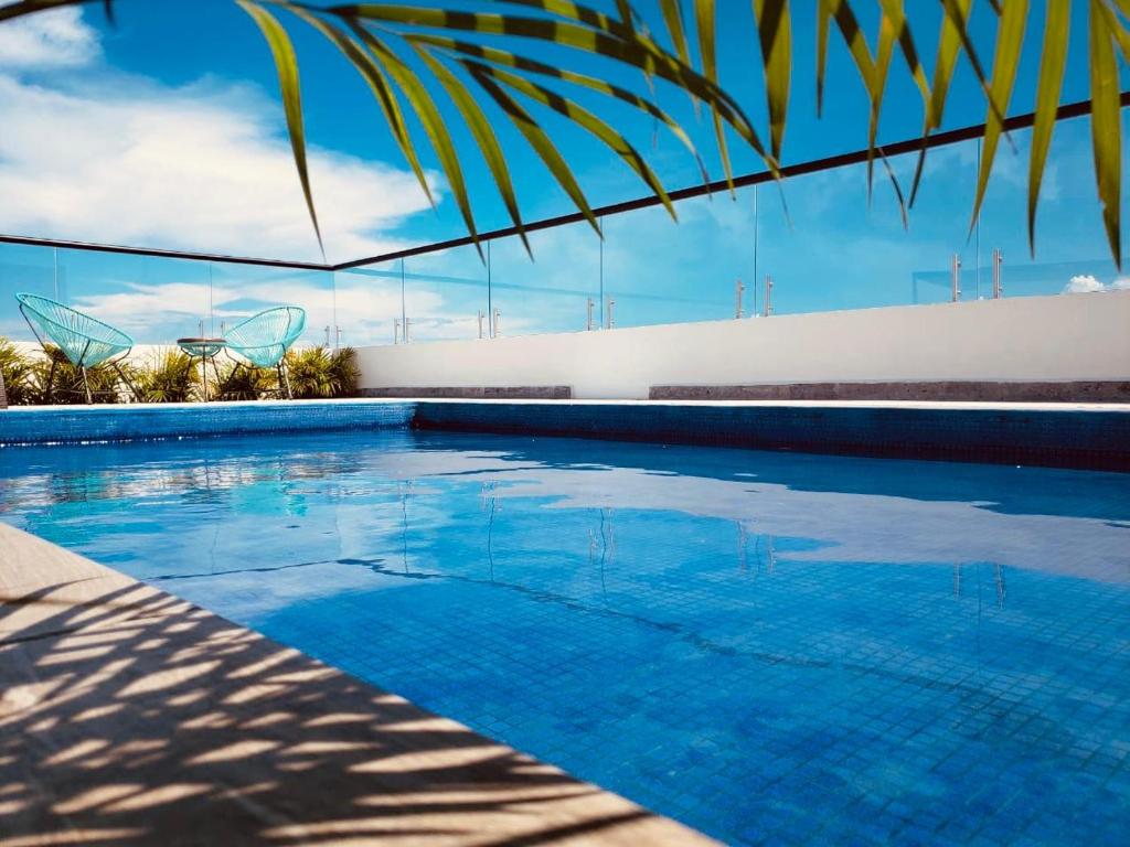 een groot zwembad met blauw water bij Meliora by Bunik in Playa del Carmen