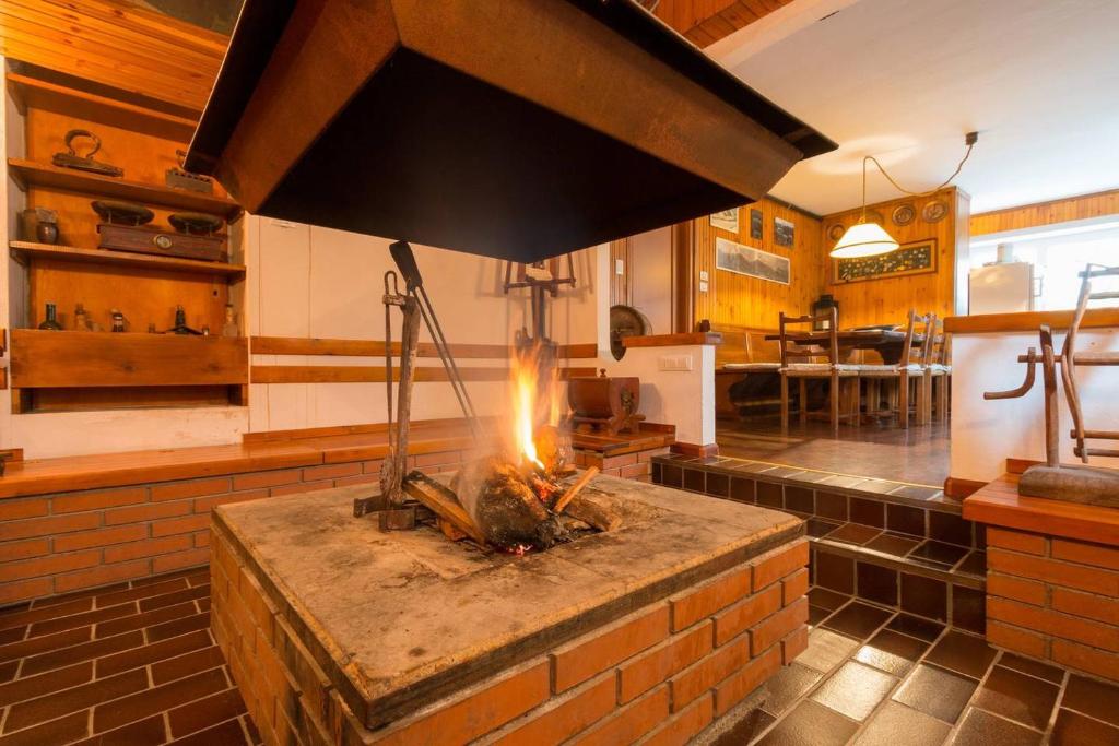 cocina con estufa de ladrillo en una habitación en La Casa di Michela - 120m2 in the mountains with fireplace & garden, en Strigno