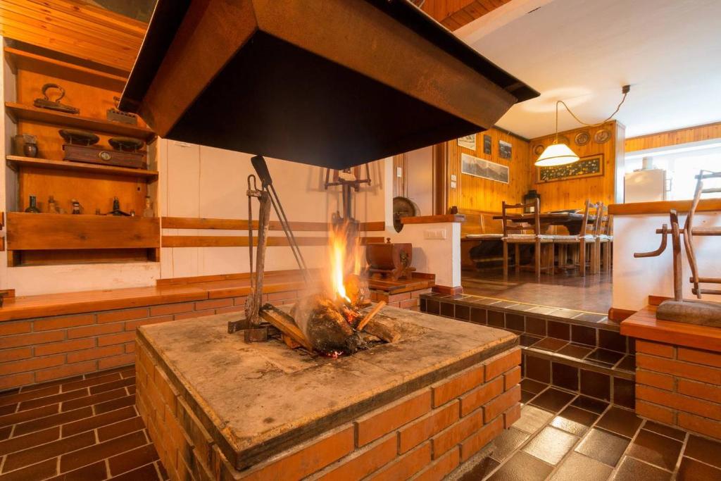 kuchnia z piecem ceglanym w pokoju w obiekcie La Casa di Michela - 120m2 in the mountains with fireplace & garden w mieście Strigno
