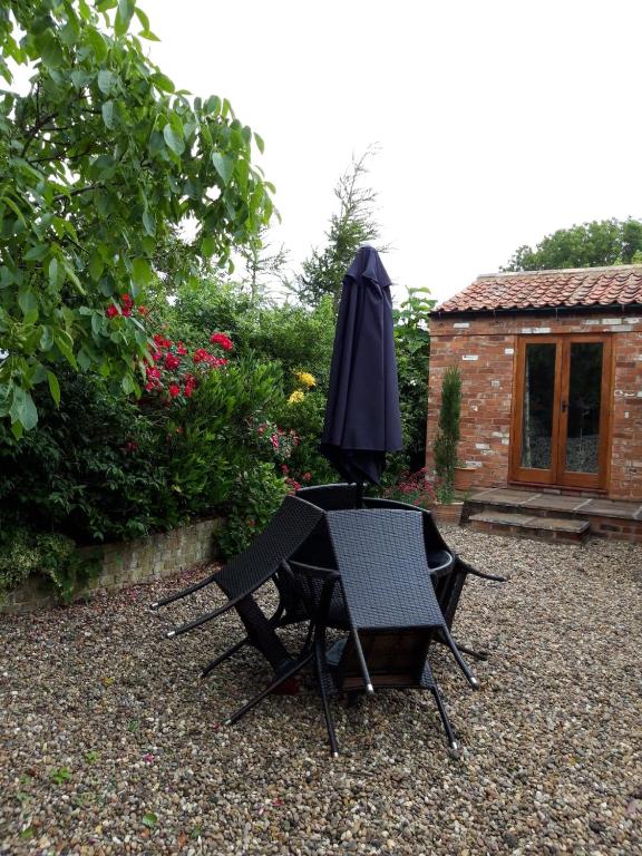 a table and chairs with an umbrella in a garden at Wolds View in Cornisholme