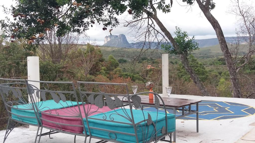 a table and chairs with a view of a mountain at Morada dos Elfos in Vale do Capao