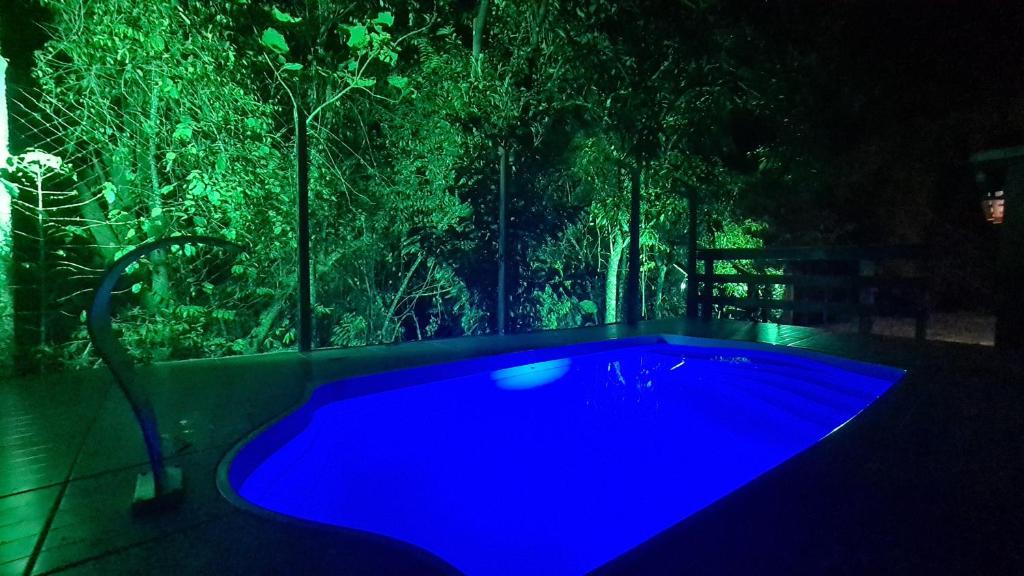 a swimming pool in a dark room with blue lighting at Casa Canastra in Vargem Bonita