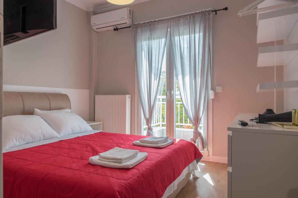 een slaapkamer met een rood bed en handdoeken erop bij modern style home near the train station in Thessaloniki