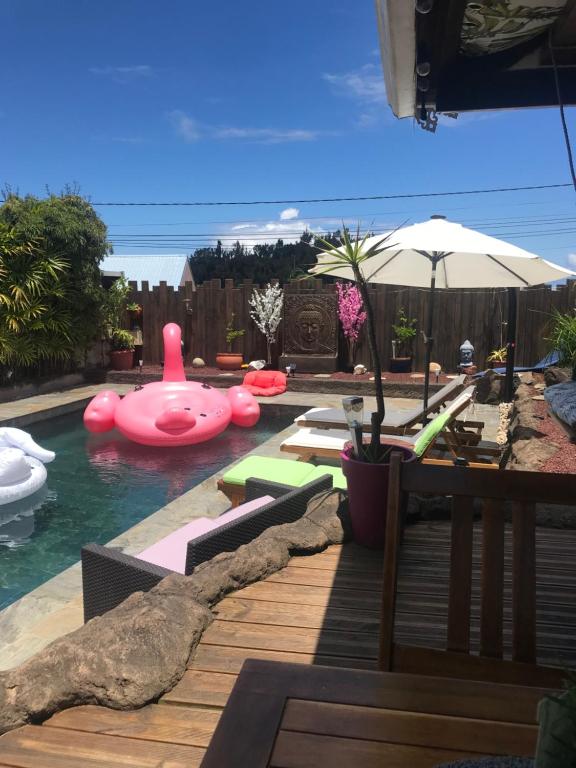 una piscina con un cerdo rosado inflable en el agua en La Villa Citronnier, en Petite Île