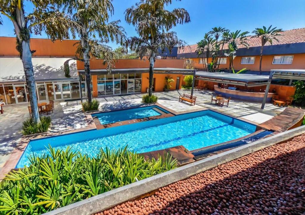 an image of a swimming pool in front of a building at Carlton Plaza Baobá in Taubaté