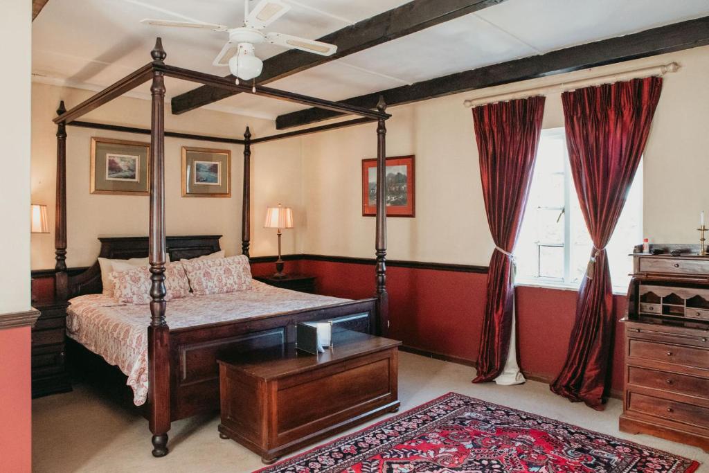 a bedroom with a canopy bed and a window at The Historic Pig and Whistle Inn in Bathurst