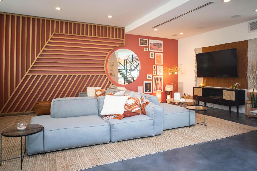 a living room with a blue couch and a piano at Haven Coliving in Los Angeles