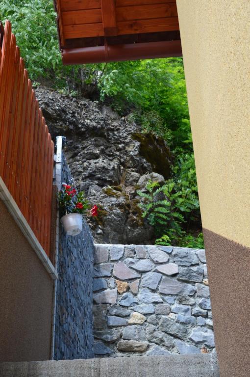 uma escada de pedra com uma parede de pedra ao lado de uma cerca em Cazare 77 em Praid