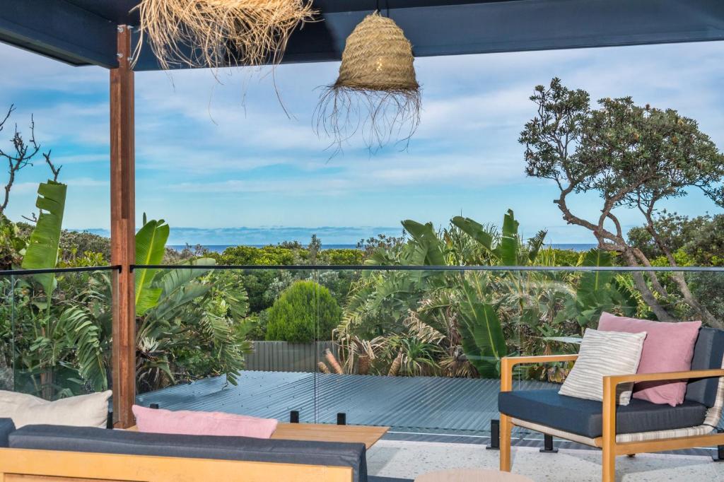 a patio with chairs and a view of the ocean at Ocean Suites Byron Bay in Byron Bay