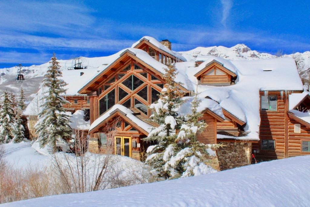 una casa de madera en la nieve con árboles nevados en Mountain Lodge at Telluride, en Telluride